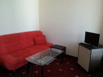 a living room with a red couch and a tv at Maverick Hotel in Sunny Beach
