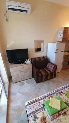 a living room with a couch and a tv at Студия първа линия Черноморец in Chernomorets