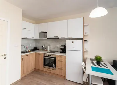 a kitchen with a white refrigerator and a table at Apartment Galia in Burgas city center in Burgas City