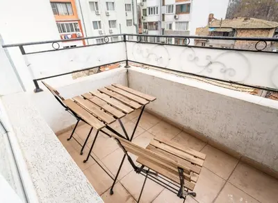 a balcony with a table and a bench on a balcony at Apartment Galia in Burgas city center in Burgas City