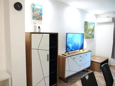 a living room with a tv and a cabinet with a tv at San Stefano Elite Apartment in Varna City