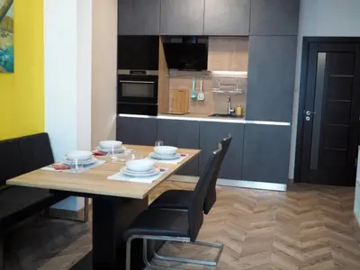 a kitchen with a wooden table and a dining room at San Stefano Elite Apartment in Varna City