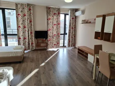 a room with a bed and a table and a television at Ilarion 5 studio at Top Center in Varna City
