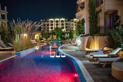 a pool at a hotel at night at Menada Harmony Suites X in Burgas City