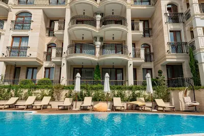 a hotel with a swimming pool in front of a building at Menada Harmony Suites X in Burgas City
