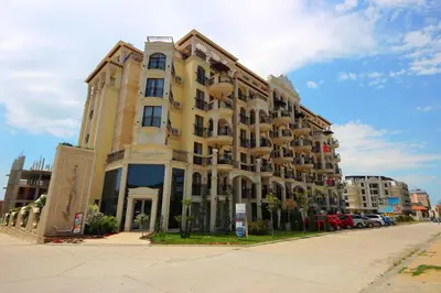 a large yellow building on the side of a street at Menada Harmony Suites X in Burgas City