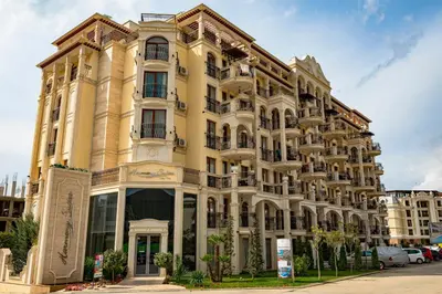 a large yellow building on a street at Menada Harmony Suites X in Burgas City