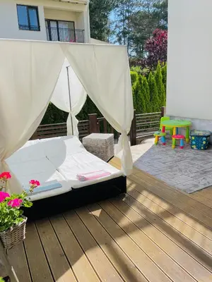 a bed on a wooden deck with a canopy at Arapya Beach Apartment in Tsarevo