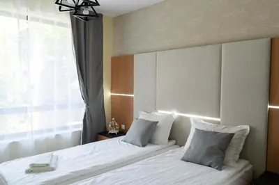 a bedroom with two beds and a window at La Familia Apartments in Varna City
