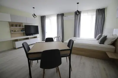 a bedroom with a bed and a table and chairs at La Familia Apartments in Varna City