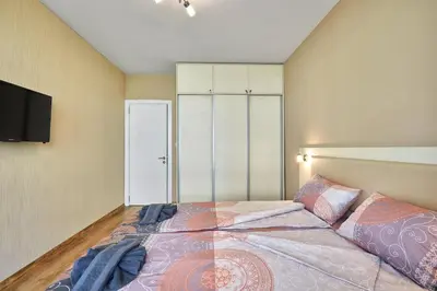 a bedroom with a bed and a tv on a wall at RELAX CENTER Burgas & Free PARKING in Burgas City