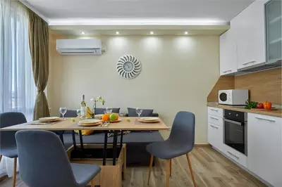 a kitchen with a table and chairs in a room at ROMANCE APARTAMENT & Free Parking in Burgas City