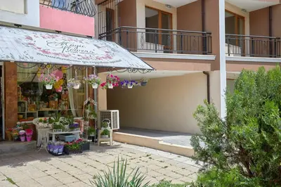 a flower shop with an umbrella in front of a building at ROMANCE APARTAMENT & Free Parking in Burgas City