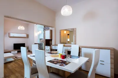 a dining room with a white table and chairs at Family Apartment - COMFORT IN THE CENTER in Burgas City