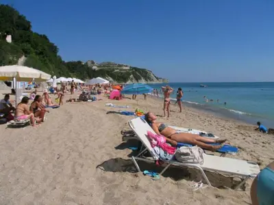a group of people sitting on a beach at Sun Village Villa 6 in Byala