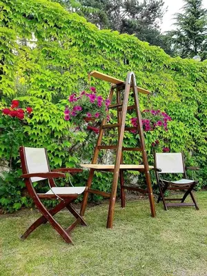 a wooden ladder and two chairs in a garden at Milennia Family Hotel in Sunny Beach