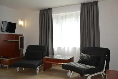 a hotel room with two chairs and a table and a window at Milennia Family Hotel in Sunny Beach