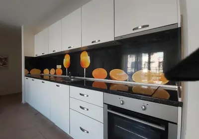 a kitchen with white cabinets and a stove with pans at 2 Zimmer Wohnung in Sunny Beach