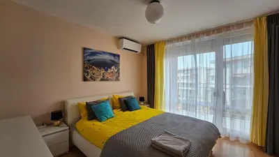 a bedroom with a yellow bed and a window at 2 Zimmer Wohnung in Sunny Beach