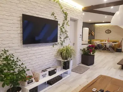 a living room with a tv on a brick wall at Синьо лято in Burgas City