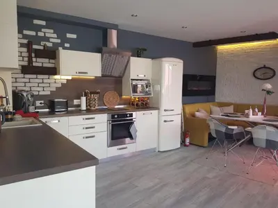 a kitchen with white appliances and a living room at Синьо лято in Burgas City