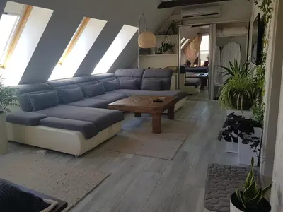 a living room with a blue couch and a table at Синьо лято in Burgas City