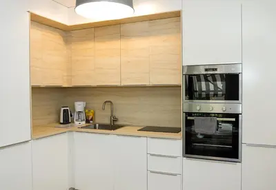 a kitchen with white cabinets and a stainless steel oven at Stylish Retreat High-end Flat Varna Downtown by Flat Mаnager in Varna City