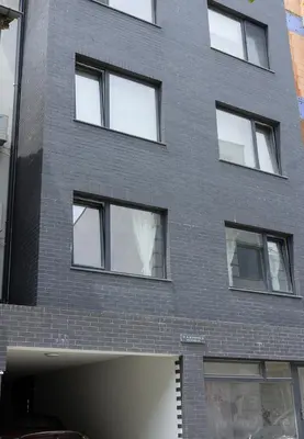 a gray brick building with white windows at Stylish Retreat High-end Flat Varna Downtown by Flat Mаnager in Varna City