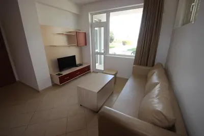 a living room with a couch and a television at Menada Apolon Apartments in Sozopol