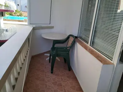 a green chair sitting in a small room with a window at Фамилна къща Джоко in Kiten
