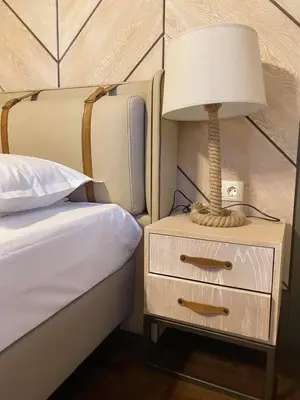 a lamp on a night stand next to a bed at Gradina Forest Villas in Sozopol