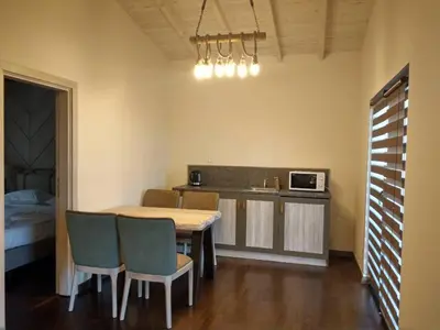 a kitchen with a table and chairs and a microwave at Gradina Forest Villas in Sozopol