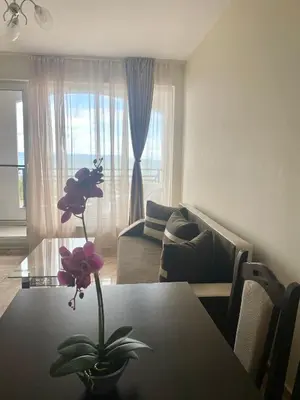 a living room with a table with a flower on it at Golden Sea View New in Pomorie