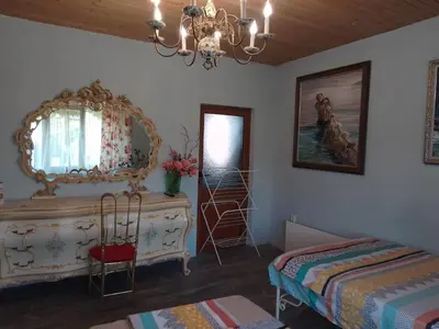 a room with a dresser and a mirror and a bed at Guest House Amazonka in Varna City