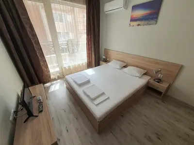a bedroom with a bed and a large window at Таня 8 in Pomorie