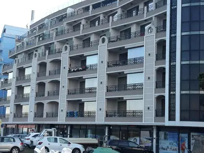an apartment building with cars parked in front of it at Таня 8 in Pomorie
