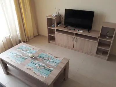 a living room with a tv and a coffee table at Таня 8 in Pomorie