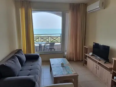 a living room with a couch and a view of the ocean at Таня 8 in Pomorie