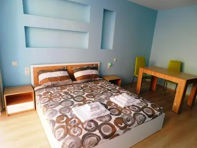 a bedroom with a bed and a wooden table at HomeLine Kazakovi in Nesebar