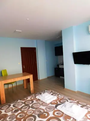 a living room with a table and a blue wall at HomeLine Kazakovi in Nesebar