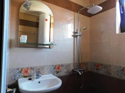 a bathroom with a sink and a shower with a mirror at HomeLine Kazakovi in Nesebar