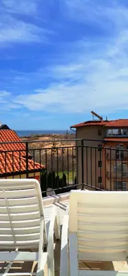 two white chairs sitting on top of a balcony at HomeLine Kazakovi in Nesebar