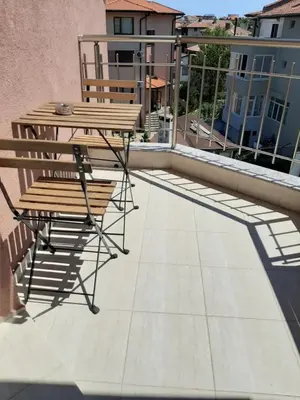 a patio with a table and a bench on a balcony at La MER 2 in Tsarevo