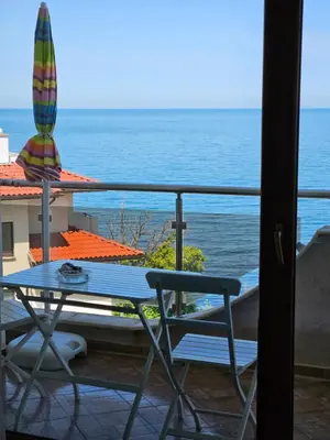 a table and chairs on a balcony with the ocean at INESA in Tsarevo