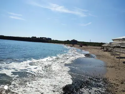a beach with people walking on the sand and water at INESA in Tsarevo