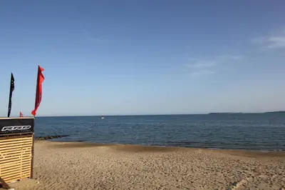 a sign on the beach with the ocean in the background at Charming 1 Bedroom Apartment for up to 4 Guests in Sunny Beach