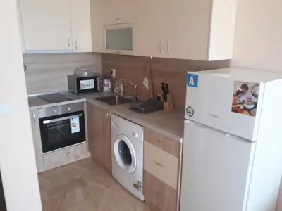 a kitchen with a white refrigerator and a washing machine at Таня 11 in Pomorie