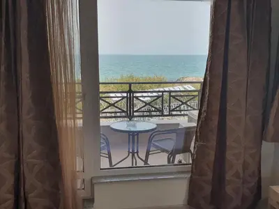 a room with a balcony with a table and the ocean at Таня 11 in Pomorie