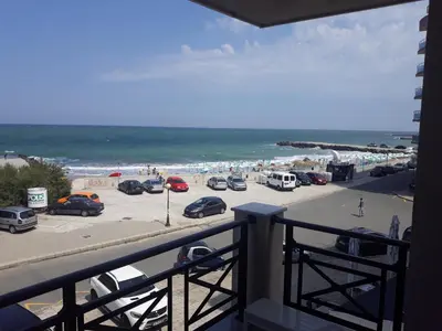 a view of a beach with cars parked in a parking lot at Таня 11 in Pomorie