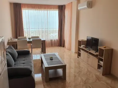 a living room with a couch and a tv and a table at Таня 11 in Pomorie
